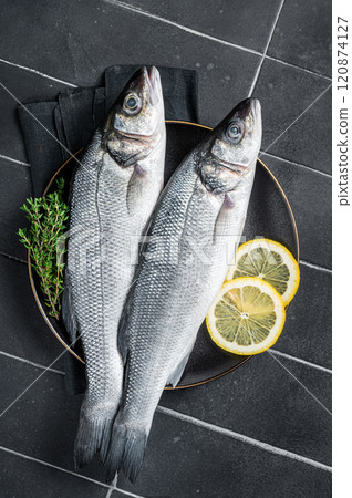 Fresh Raw Sea Bass fish with lemon and thyme. Black background. Top view Fresh Raw Sea Bass fish with lemon and thyme. Black background. Top view 120874127