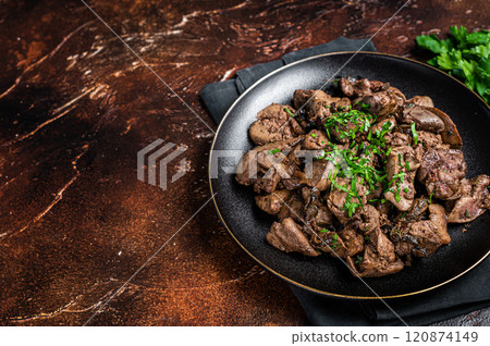 Fried chicken liver with onions and parsley in a plate. Dark background. Top view. Copy space Fried chicken liver with onions and parsley in a plate. Dark background. Top view. Copy space 120874149