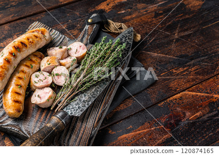 Sliced grilled pork meat sausages on a wooden serving board. Wooden background. Top view. Copy space 120874165