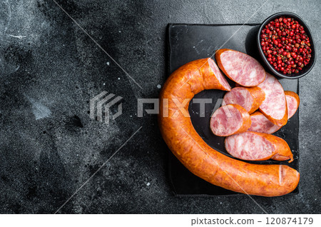 Smoked sausage on a marble board. Black background. Top view. Copy space Smoked sausage on a marble board. Black background. Top view. Copy space 120874179