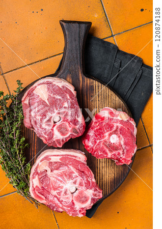 Raw lamb neck chops, fresh mutton meat on a butcher board with herbs. Orange background. Top view 120874188