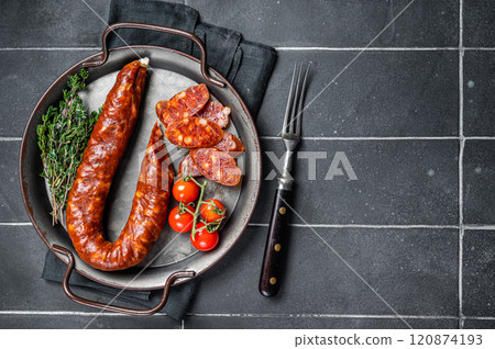 Sliced Chorizo sausage, slices of dry cured pork with herbs and spices. Black background. Top view. Copy space 120874193