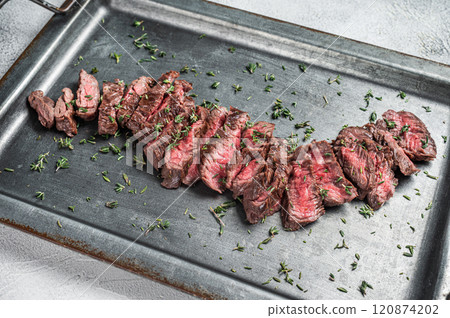 Sliced Grilled Machete skirt beef meat steak. Gray background. Top view. Copy space Sliced Grilled Machete skirt beef meat steak. Gray background. Top view. Copy space 120874202