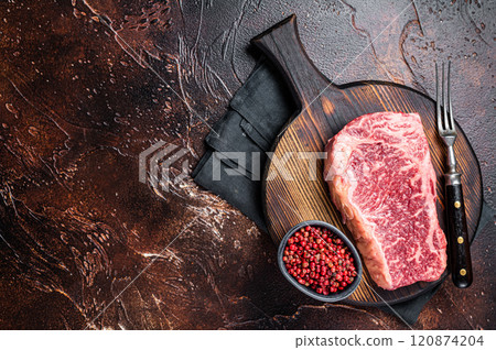Uncooked Raw striploin or club steak on wooden board with thyme. Dark background. Top view. Copy space 120874204