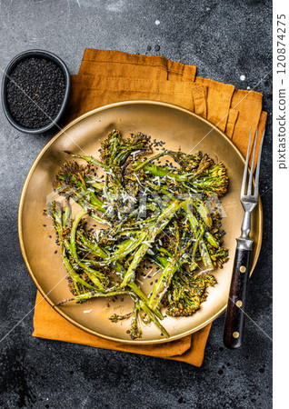 Salad with roasted Broccolini Sprouts, parmesan cheese and garlic. Black background. Top view Salad with roasted Broccolini Sprouts, parmesan cheese and garlic. Black background. Top view 120874275