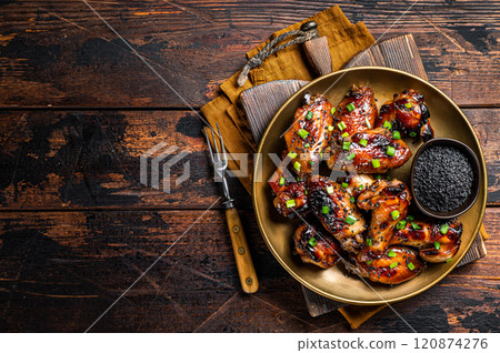Teriyaki chicken wings with black sesame in a plate. Wooden background. Top view. Copy space Teriyaki chicken wings with black sesame in a plate. Wooden background. Top view. Copy space 120874276
