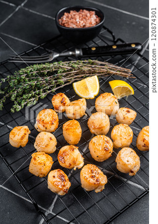 Grilled Scallops fillets on a rack. Black background. Top view 120874301