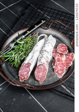 Fuet Salami slices in a steel tray. Traditional Spanish sausage. Black background. Top view 120874310