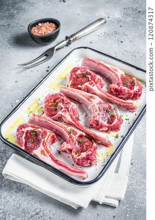 Ready for cooking raw lamb chop steaks with spices and herbs. Gray background. Top view Ready for cooking raw lamb chop steaks with spices and herbs. Gray background. Top view 120874317