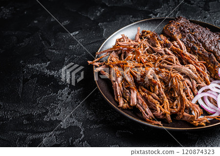 BBQ pulled pork meat on plate. Black background. Top view. Copy space 120874323