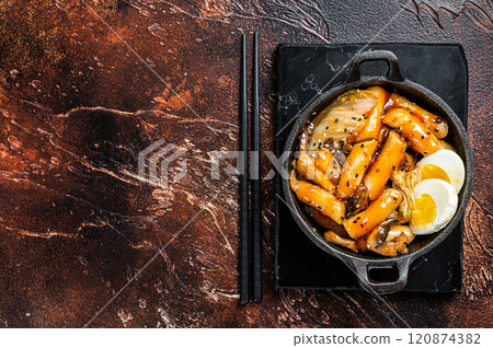 Korean Topokki or Tteokbokki rice cake with egg and mashrooms. Dark background. Top view. Copy space 120874382