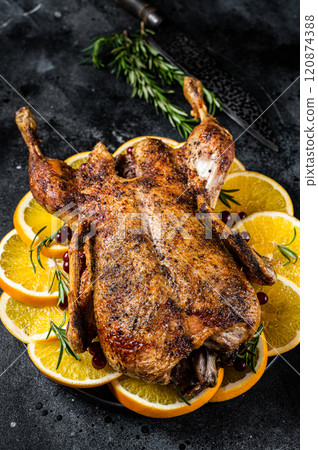 Christmas dinner, baked duck with rosemary and oranges, crispy whole roast duck. Black background. Top view 120874388