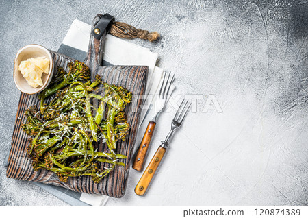 Baked Broccolini cabbage Sprouts with parmesan cheese on wooden board. White background. Top view. Copy space Baked Broccolini cabbage Sprouts with parmesan cheese on wooden board. White background. Top view. Copy space 120874389