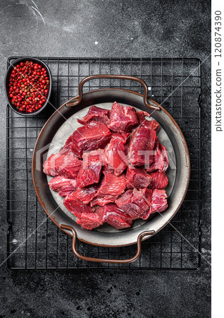 Raw Diced venison dear meat for a goulash, game meat. Black background. Top view Raw Diced venison dear meat for a goulash, game meat. Black background. Top view 120874390