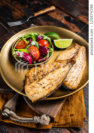 Roasted Gilthead Sea Bream fillets served with fresh vegetable salad. Wooden background. Top view 120874396
