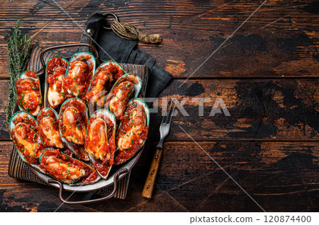 Delicious seafood mussels cooked in tomato sauce with garlic, herbs. Wooden background. Top view. Copy space 120874400
