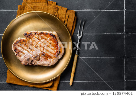 BBQ fried pork T bone chop meat steak on a plate. Black background. Top view. Copy space 120874401