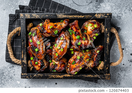 BBQ Chicken wings in Teriyaki sauce with black sesame in a tray. Gray background. Top view 120874403