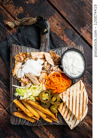 Kebab, Shawarma, Gyro grilled meat with french fries and vegetables on a wooden board. Wooden background. Top view 120874419