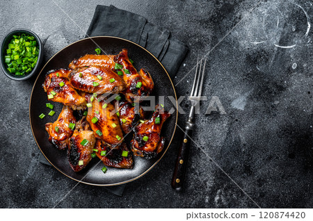 Baked chicken wings with sweet chili sauce in a plate. Black background. Top view. Copy space Baked chicken wings with sweet chili sauce in a plate. Black background. Top view. Copy space 120874420