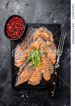 Salmon carpaccio with microgreens on marble board. Black background. Top view 120874441