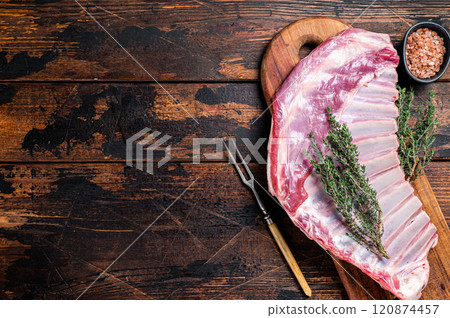Raw lamb mutton ribs with herbs on wooden board. Wooden background. Top view. Copy space 120874457