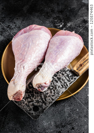 Fresh turkey legs Drumsticks, raw Poultry meat with butcher cleaver. Black background. Top view 120874463