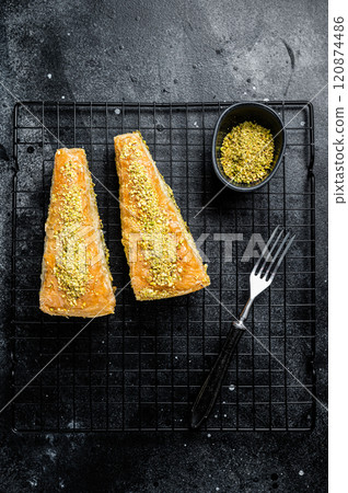 Turkish delights Havuc Dilim Baklava with pistachio and honey. Black background. Top view Turkish delights Havuc Dilim Baklava with pistachio and honey. Black background. Top view 120874486