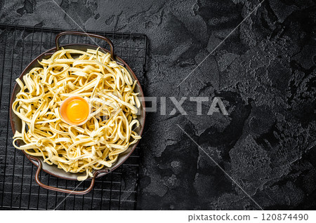 Dry spaetzle egg noodle in a steel tray. Black background. Top view. Copy space Dry spaetzle egg noodle in a steel tray. Black background. Top view. Copy space 120874490