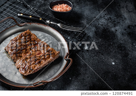 Alternative choice steak - Grilled Skirt or Machete beef meat. Black background. Top view. Copy space Alternative choice steak - Grilled Skirt or Machete beef meat. Black background. Top view. Copy space 120874491