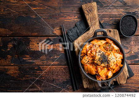Kimchi salted and fermented chinese cabbage in a skillet. Wooden background. Top view. Copy space Kimchi salted and fermented chinese cabbage in a skillet. Wooden background. Top view. Copy space 120874492