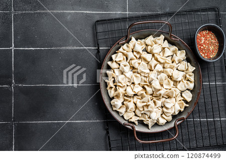 Cooking Manti Dumpling, raw food in a steel tray. Black background. Top view. Copy space 120874499