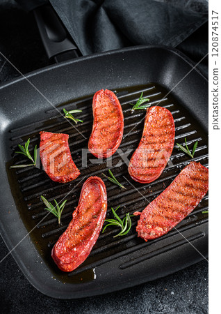 Fried Turkish Sucuk meat sausage on a grill skillet. Black background. Top view 120874517