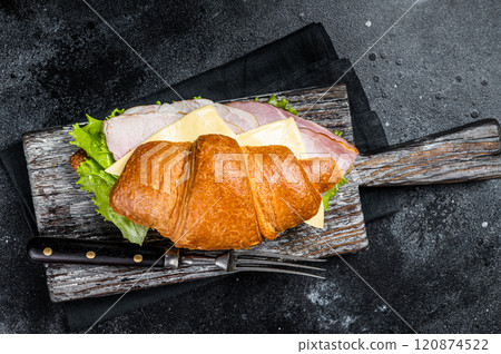 Croissant Club Sandwich with Ham and Cheese, cup of coffe. Black background. Top view 120874522