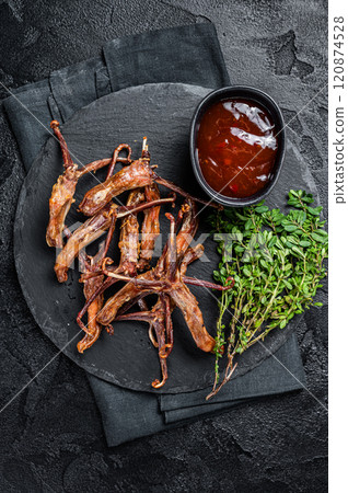 Cooked Spicy fried duck tongue. Black background. Top view Cooked Spicy fried duck tongue. Black background. Top view 120874528