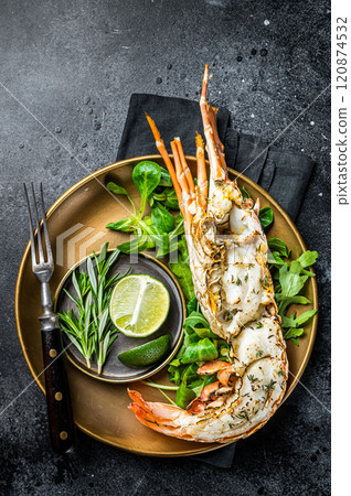 Grilled Spiny lobster with salad on a plate. Black background. Top view Grilled Spiny lobster with salad on a plate. Black background. Top view 120874532