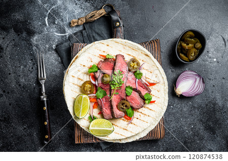 Tacos of mexican beef fajitas alambre with onion, jalapeno and bell pepper. Black background. top view 120874538