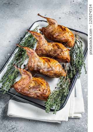 Homemade sticky Roast quails with spices and herbs in a baking dish. Gray background. Top view Homemade sticky Roast quails with spices and herbs in a baking dish. Gray background. Top view 120874554
