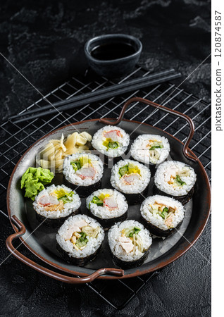 Kimbap gimbap filled with vegetables, egg, eanchovy and crab, Korean rice roll. Black background. Top view Kimbap gimbap filled with vegetables, egg, eanchovy and crab, Korean rice roll. Black background. Top view 120874587