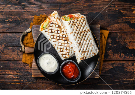 Shawarma, Shaurma chicken roll with vegetable salad. Wooden background. Top view Shawarma, Shaurma chicken roll with vegetable salad. Wooden background. Top view 120874595