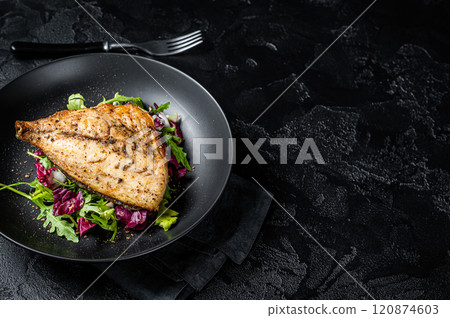 Grilled Sea Bream Dorado fillets served on fresh salad. Black background. Top view. Copy space 120874603