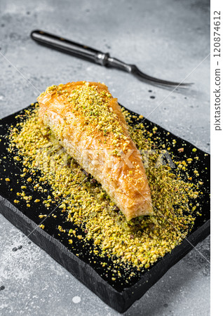 Turkish Dessert Havuc Dilim Baklava with pistachio and honey. Gray background. Top view Turkish Dessert Havuc Dilim Baklava with pistachio and honey. Gray background. Top view 120874612