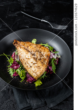 Grilled Sea Bream Dorado fillets served on fresh salad. Black background. Top view Grilled Sea Bream Dorado fillets served on fresh salad. Black background. Top view 120874629