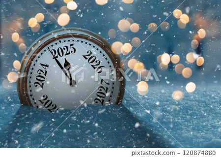 Vintage clock in the snow and points to the new year 2025. Beautiful winter background with golden lights bokeh at evening. New Year and Christmas Countdown, creative idea. 120874880