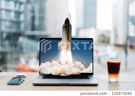 Creative laptop with space rocket taking off on desktop. Creative idea, concept. Go beyond the possible. Space shuttle rocket with smoke cloud takes off from laptop. Strategy and a successful startup 120875040