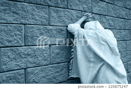 Young woman pray at the wall 120875247