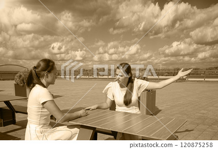 Girls arguing in a cafe Girls arguing in a cafe 120875258