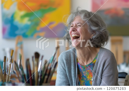 Joyful elderly woman laughing in art studio 120875283