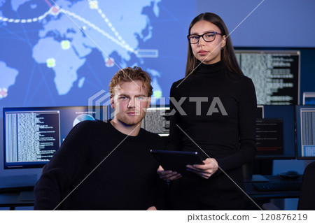 Professional serious cyber security team in front of cybersecurity SIEM system with logs and incident map 120876219