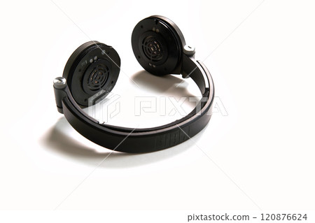 Black headphones on a white isolated background.The headphones are broken and symbolize broken equipment and its repair. High angle 120876624